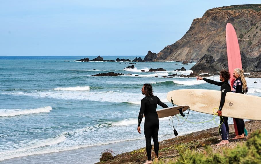 A group of people with surfboards looking at the ocean