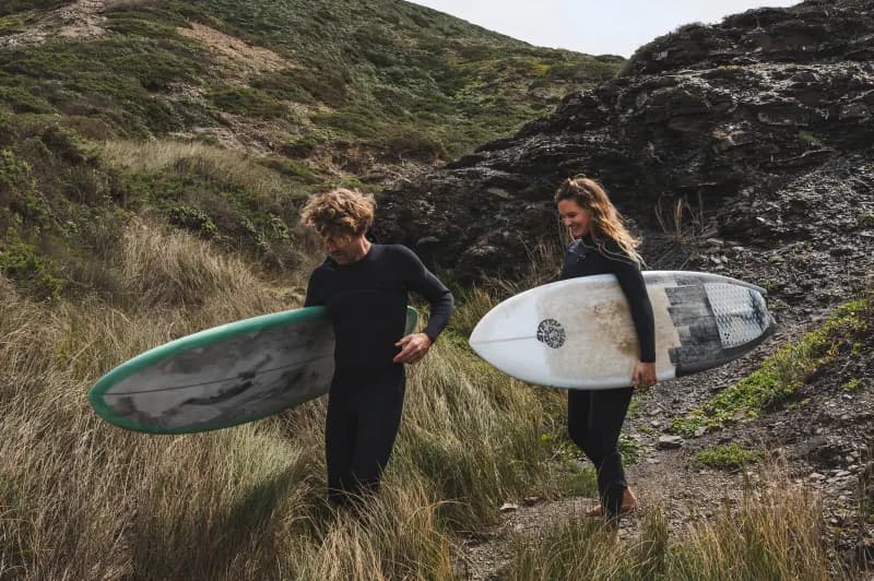 Surfers holding surfboards in their arms