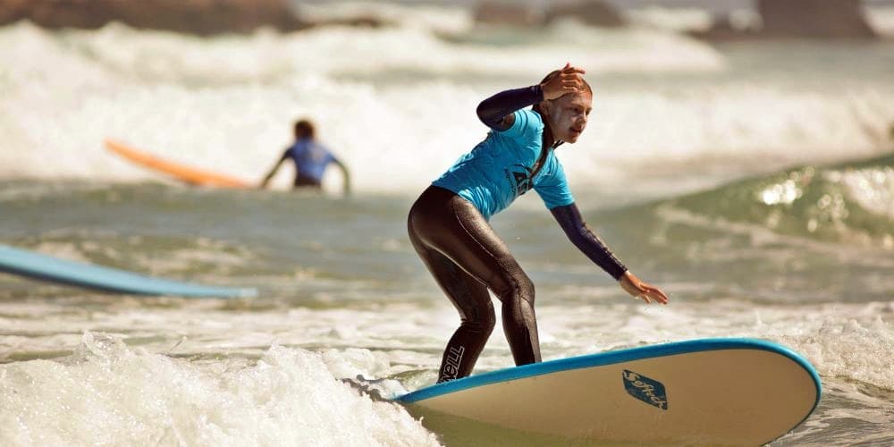 Kid riding a wave on a surfboard in Lagos